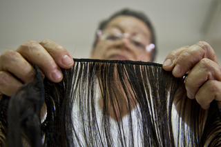 A former cancer patient weaves natural hair to make wigs on World Cancer Day on Feb. 4, 2014, at a foundation in Cali, Colombia. (Luis Robayo/AFP/Getty Images)